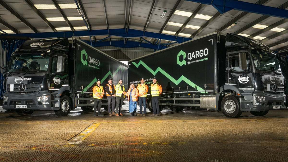 Qargo team standing in front of two trucks