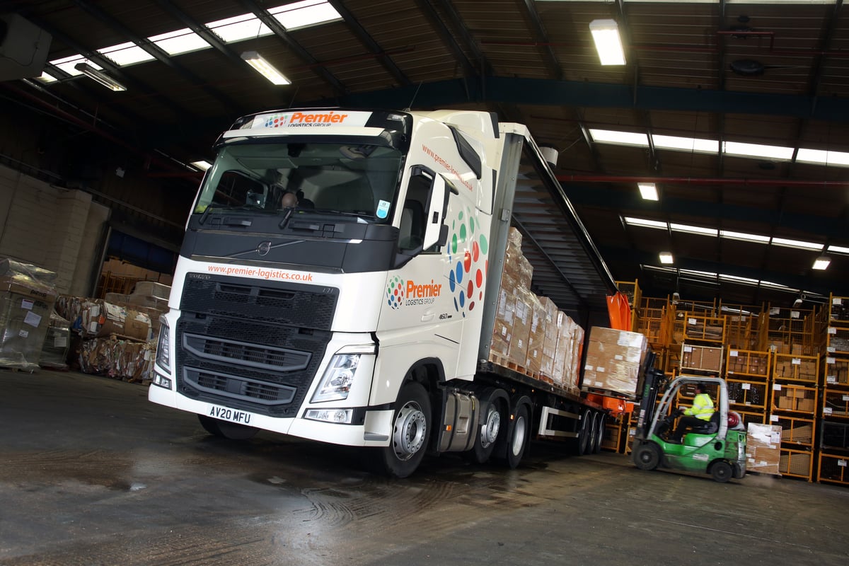 Vrachtwagen van Premier Logistics die in een magazijn wordt geladen