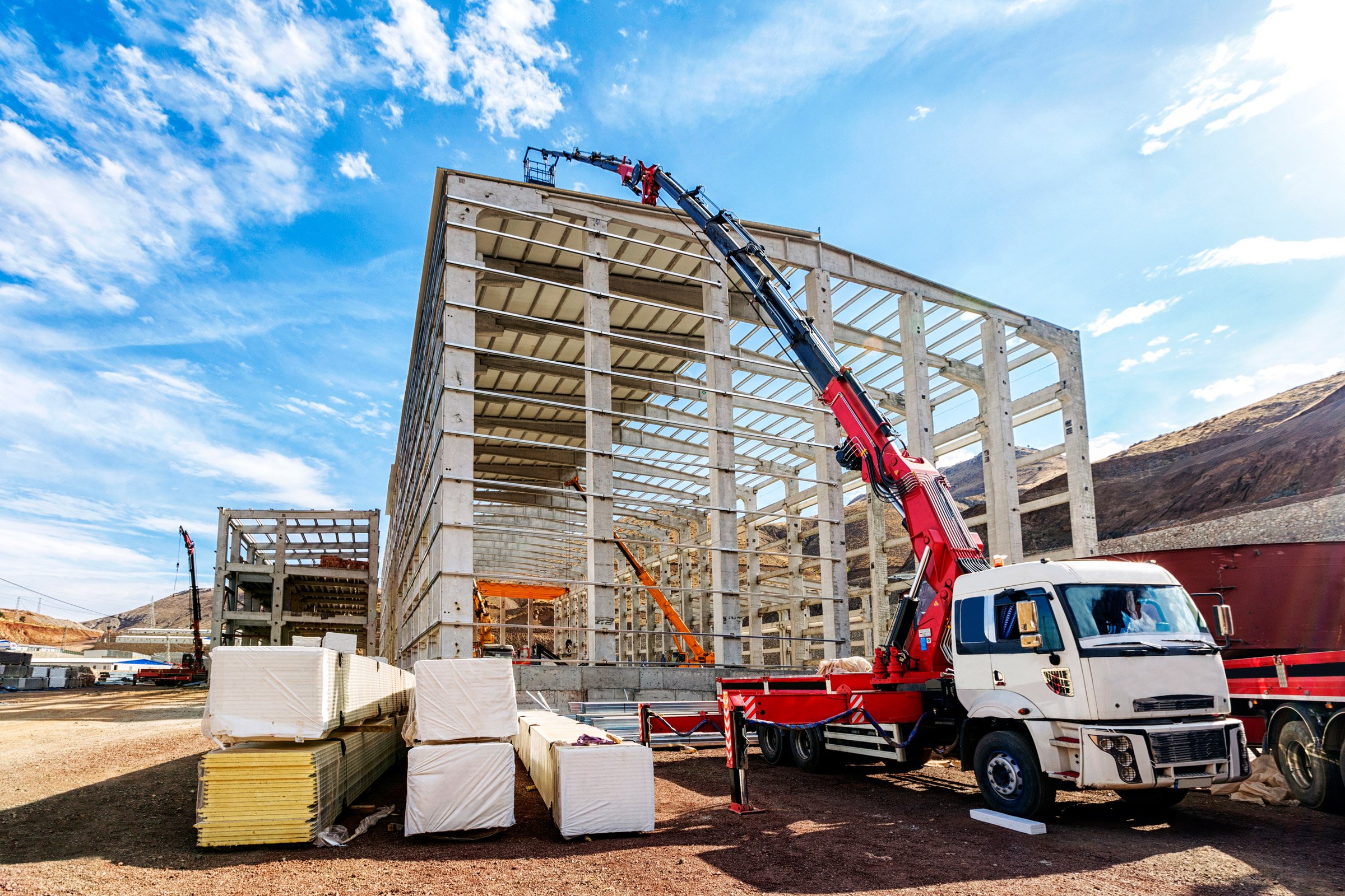 HIAB-kraanwagen die materiaal hijst op een bouwwerf