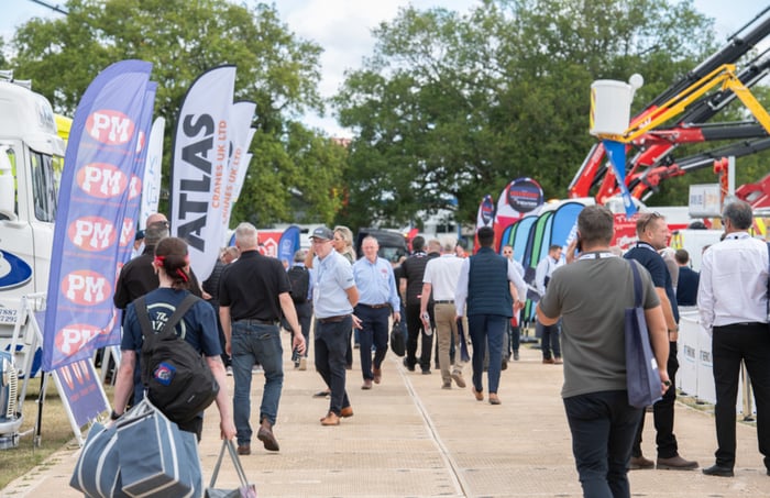 Visiteurs marchant entre les stands d'un salon du transport en plein air