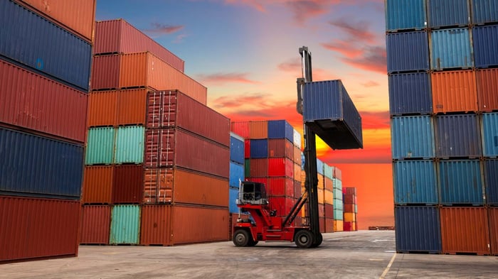 Forklift handling a container between stacks