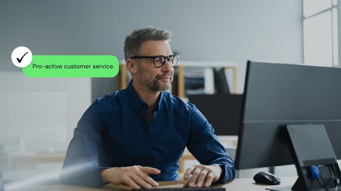Office worker at a computer with a proactive customer service label
