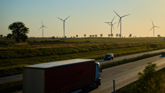 Lorry driving on road next to wind turbines